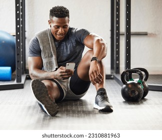 Fitness, phone and black man typing in gym on break after exercise, training or workout. Athlete, smartphone and happy African male person on sports app, networking or social media, email and relax. - Powered by Shutterstock