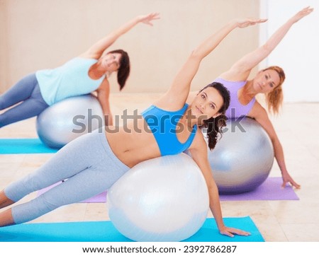 Fitness, pilates class and women on ball in workout, training and wellness coach with balance and portrait. Personal trainer and group of people stretching on floor for body exercise or muscle health