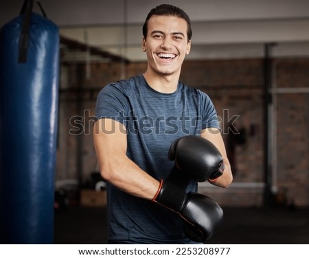 Fitness, portrait and man with boxing gloves in gym for training, exercise or training. Happy, smile and male athlete or boxer doing cardio kickboxing workout for health or wellness in sports studio.