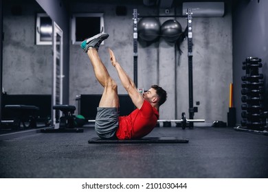 Fitness routine and weight loss, sports life. Man correctly performs demanding core exercises on the pathos of the modern gym and sports center concept. Individual training and achieving fitness goals - Shutterstock ID 2101030444