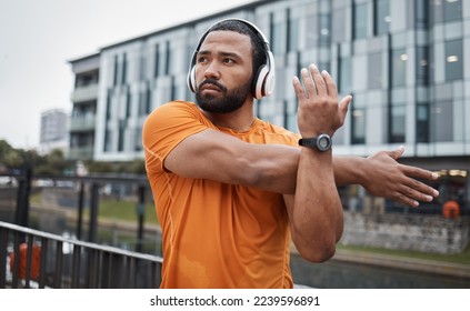 Fitness, runner or black man stretching in city for running training, cardio exercise or workout start in London. Wellness, mindset or healthy sports athlete in headphones streaming radio or podcast - Powered by Shutterstock