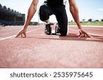 Fitness runner, hands and start block at stadium race track, sports or professional athlete training. Field, ready and man prepared for sprint competition, speed or fast performance outdoor on ground