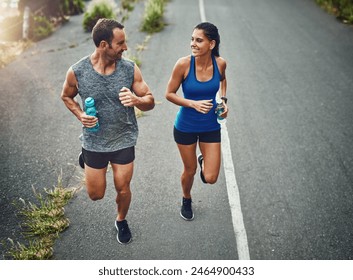 Fitness, running and couple with smile, race and bottle for hydration with water and outdoor. Road, exercise and people in morning, sportswear and training together, energy and workout in routine - Powered by Shutterstock