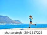 Fitness, running and girl on beach with blue sky, marathon training or outdoor exercise on mockup space. Ocean, mountain or woman runner on morning workout in nature for body care, health or wellness