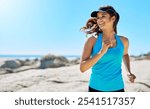 Fitness, running and happy woman on beach with blue sky, marathon training and outdoor exercise on island. Ocean, smile and girl runner on morning workout in nature for body care, health and wellness