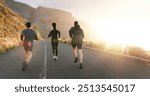 Fitness, running and sports with friends in mountains together for cardio challenge or performance. Exercise, raining or workout with athlete men and woman on asphalt road in nature from back