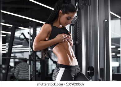 Fitness sexy woman showing abs and flat belly. Beautiful muscular girl, shaped abdominal