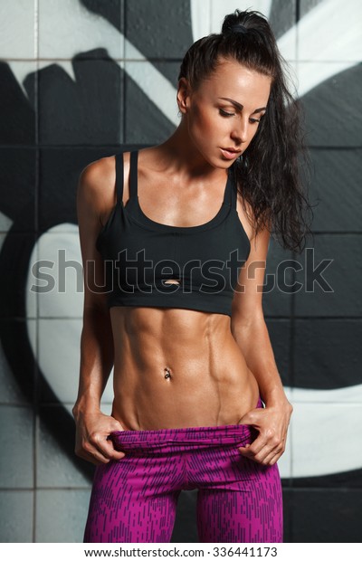 腹筋と平腹を見せるフィットネスセクシーな女性 腹部の形をした 細い腰の美しい筋肉質の女の子 の写真素材 今すぐ編集