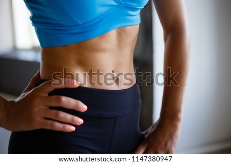 Fitness, sport, active lifestyle, excellent shape. Fit woman with perfect six-pack abs close up