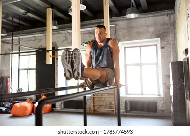 Fitness, Sport, Bodybuilding And People Concept - Young Man Doing Abdominal Exercise On Parallel Bars In Gym