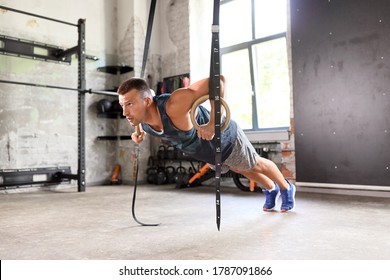 fitness, sport, bodybuilding and people concept - young man doing push-ups on gymnastic rings in gym - Powered by Shutterstock