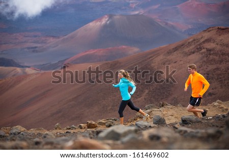 Fitness sport couple jogging outside, training together outdoors. Running on amazing trail at sunset, Dramatic beautiful volcano landscape