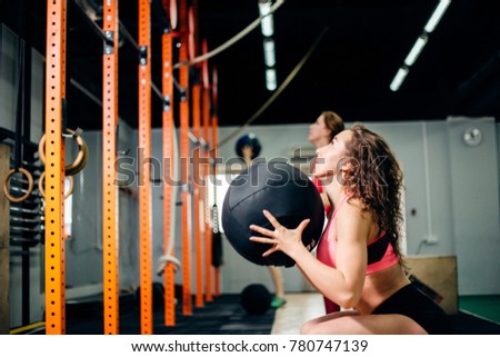 fitness, sport and exercising concept - two woman with medicine balls training in gym