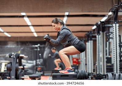fitness, sport, exercising and people concept - woman doing squats on platform in gym