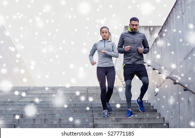 fitness, sport, exercising, people and healthy lifestyle concept - couple of sportsmen walking downstairs over snow