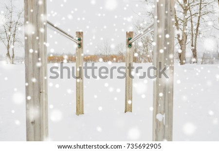 fitness, sport, exercising, training and equipment concept - parallel bars outdoors in winter