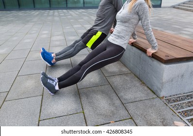 fitness, sport, exercising, training and people concept - couple doing triceps dip exercise on city street bench
