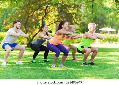 fitness, sport, friendship and healthy lifestyle concept - group of happy teenage friends or sportsmen exercising and doing squats at boot camp - Powered by Shutterstock