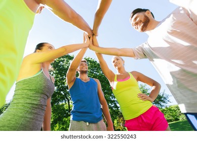 Fitness, Sport, Friendship And Healthy Lifestyle Concept - Group Of Happy Teenage Friends Or Sportsmen Making High Five Outdoors