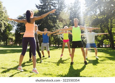 fitness, sport, friendship and healthy lifestyle concept - group of happy teenage friends or sportsmen exercising at boot camp - Powered by Shutterstock