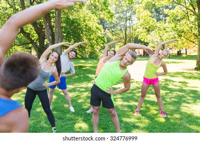 fitness, sport, friendship and healthy lifestyle concept - group of happy teenage friends or sportsmen exercising and stretching hands at boot camp - Powered by Shutterstock