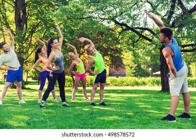 fitness, sport, friendship and healthy lifestyle concept - group of happy teenage friends or sportsmen exercising and stretching hands at boot camp - Powered by Shutterstock