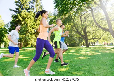 fitness, sport, friendship, race and healthy lifestyle concept - group of happy teenage friends or sportsmen running marathon with badge numbers outdoors - Powered by Shutterstock