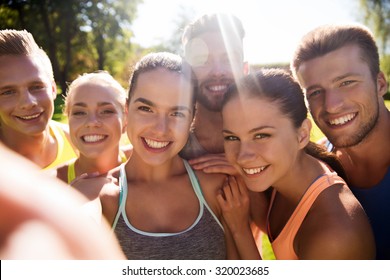 Fitness, Sport, Friendship, Technology And Healthy Lifestyle Concept - Group Of Happy Teenage Friends Taking Selfie With Smartphone Outdoors