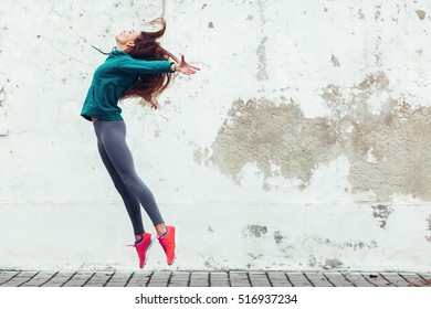 Fitness sport girl in fashion sportswear dancing hip hop in the street  outdoor sports  urban style