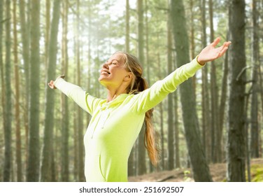 fitness, sport, happiness and people concept - happy woman raising hands over woods background - Powered by Shutterstock