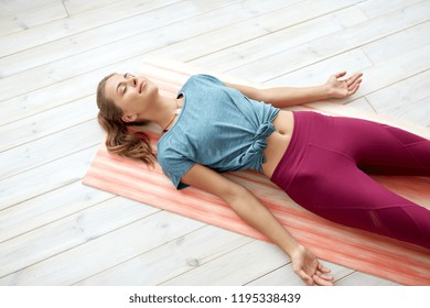 fitness, sport and healthy lifestyle concept - woman doing yoga corpse pose at studio - Powered by Shutterstock