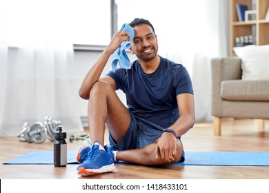 Fitness, Sport And Healthy Lifestyle Concept - Smiling But Tired Indian Man Wiping Face With Towel After Training At Home