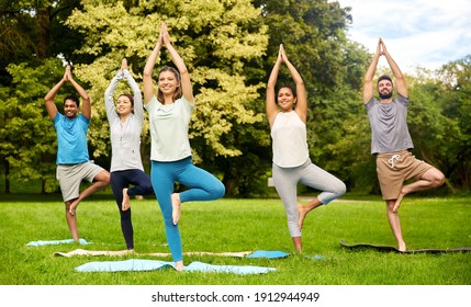 Fitness, Sport And Healthy Lifestyle Concept - Group Of Happy People Doing Yoga At Summer Park