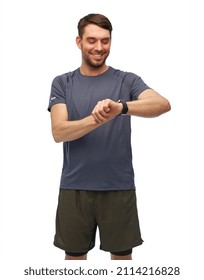 Fitness, Sport And Healthy Lifestyle Concept - Smiling Man In Sports Clothes Looking At His Smart Watch Or Tracker Over White Background