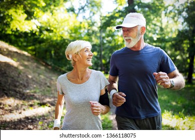 Fitness, sport, people, exercising and lifestyle concept - senior couple running - Shutterstock ID 1366118075