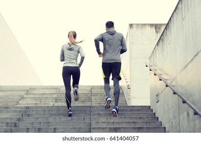 fitness, sport, people, exercising and lifestyle concept - couple running upstairs on city stairs - Shutterstock ID 641404057