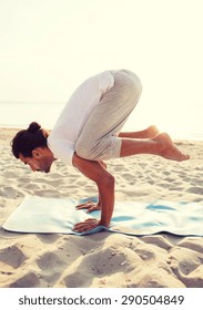 fitness, sport, people and lifestyle concept - man doing yoga exercises on mat outdoors