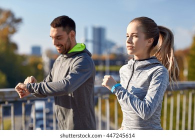 Fitness, Sport, People, Technology And Healthy Lifestyle Concept - Smiling Couple With Heart-rate Watch Running Over City Highway Bridge