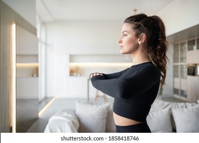 Fitness Is A Sport To Promote Health And A Strong Body. Cozy Apartment In Bright Colors Sofa Background.training Exercises Stretching In Front Of A Laptop Computer Online Trainer At Home.