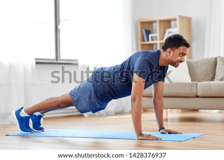 fitness, sport, training and concept - indian man doing push ups at home Foto d'archivio © 