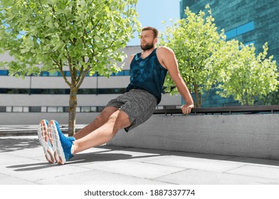 fitness, sport and training concept - young man doing triceps dip on city street