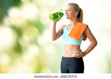 Fitness, Sport, Training, Drink And Lifestyle Concept - Woman With Bottle Of Water And Towel Over Green Natural Background