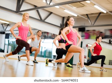 fitness, sport, training, gym and lifestyle concept - group of smiling people exercising in the gym - Shutterstock ID 164474051