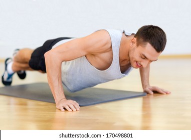 Fitness, Sport, Training, Gym And Lifestyle Concept - Smiling Man Doing Push-ups In The Gym Or At Home