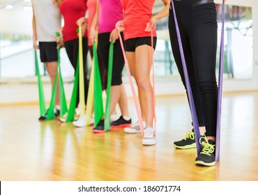 fitness, sport, training, gym and lifestyle concept - group of people with working out with rubber bands in the gym - Powered by Shutterstock