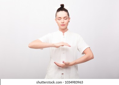 fitness, sport, training and lifestyle concept - Young woman doing yoga exercise. Young Woman praticing tai chi chuan in the gym. Chinese management skill Qi's energy.