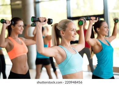 fitness, sport, training and lifestyle concept - group of women with dumbbells in gym - Powered by Shutterstock