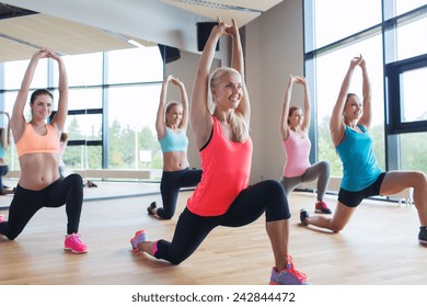 Fitness, Sport, Training, People And Lifestyle Concept - Group Of Women Making Lunge Exercise In Gym