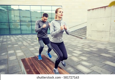 Fitness, Sport, Training, People And Lifestyle Concept - Couple Making Step Exercise On City Street Bench