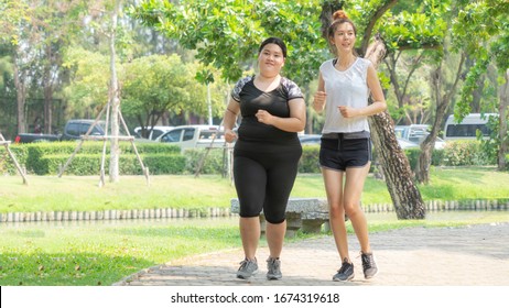 Fitness sport two slim fit and fat girls in fashion sportswear running in garden morning, outdoor sports.